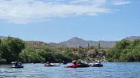 A group of people on rafts on a river.